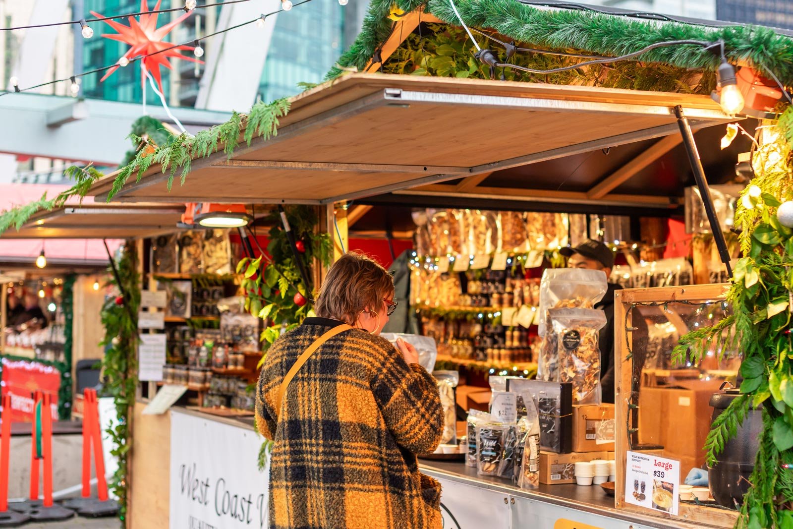 A person shopping at a vendor stall at the Vancouver Christmas Market